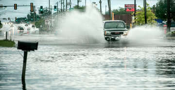 Truck plowing through flooded street